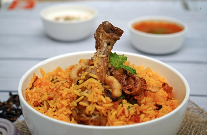 Close view of biryani rice with a tender piece of mutton