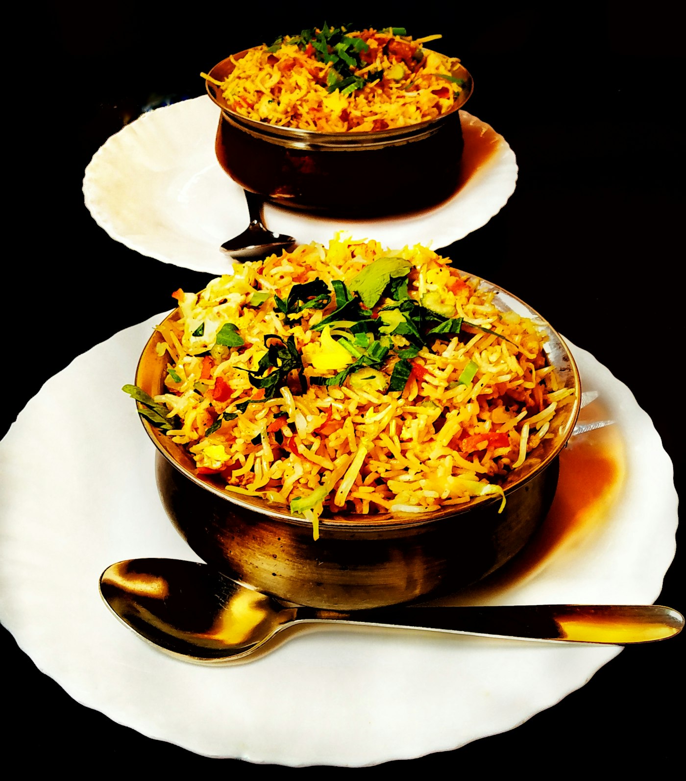 Steaming chicken biryani served in a black handi on a dark table